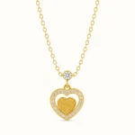 Gold Double Heart Pendant Necklace with cubic zirconia heart halo, textured gold heart center, and bezel-set accent stone