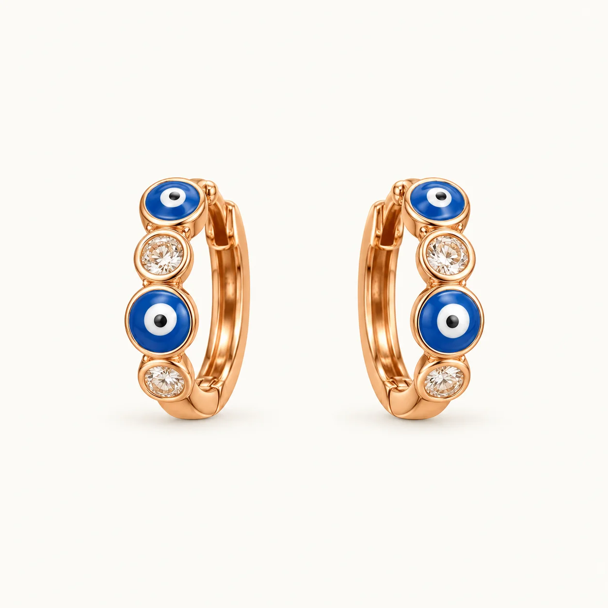 Evil Eye (Nazar) Huggie Hoop Earrings featuring alternating blue enamel evil eye motifs and bezel-set clear round crystals