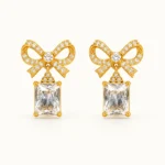 LumiBow Crystal Drop Earrings with gold bow design, sparkling white crystals, and rectangular crystal drops